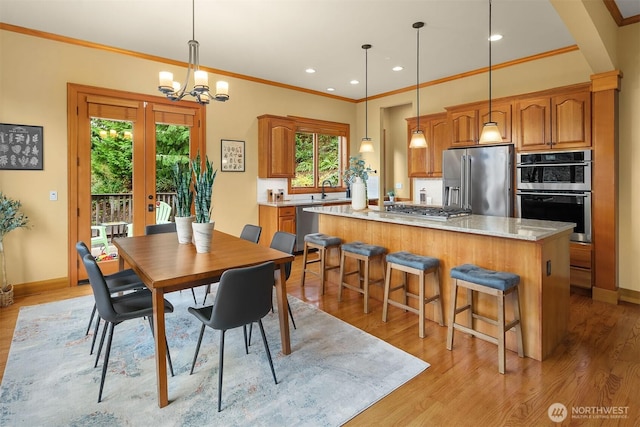 dining area with baseboards, recessed lighting, ornamental molding, light wood-style floors, and a notable chandelier