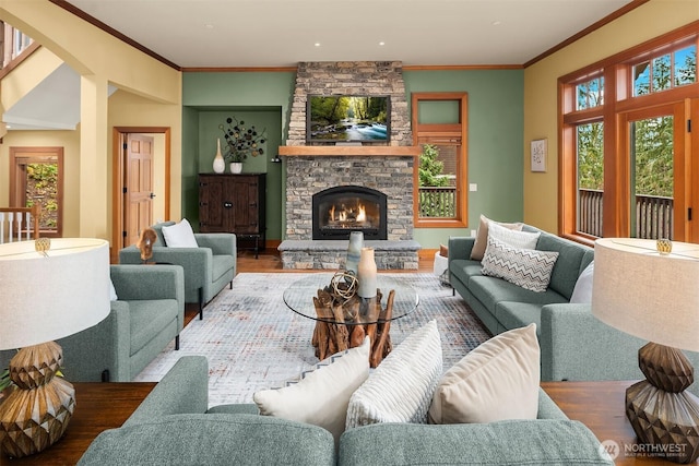 living room with ornamental molding, a fireplace, and wood finished floors