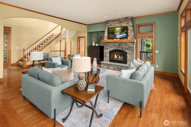 living room with stairs, wood finished floors, a fireplace, and baseboards