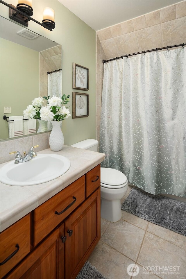 bathroom with visible vents, toilet, curtained shower, and vanity