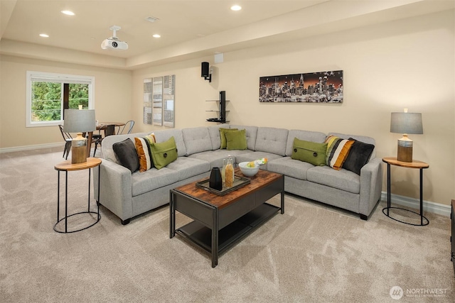 living area with a raised ceiling, recessed lighting, baseboards, and light carpet