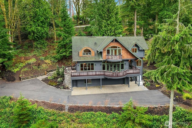 back of house featuring a balcony and driveway