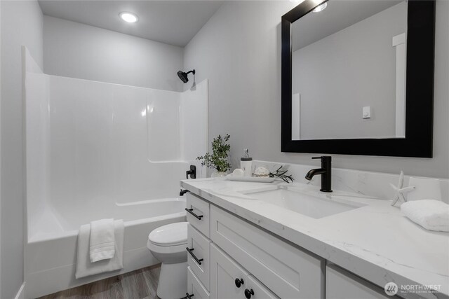 full bath with toilet, vanity, bathtub / shower combination, and wood finished floors