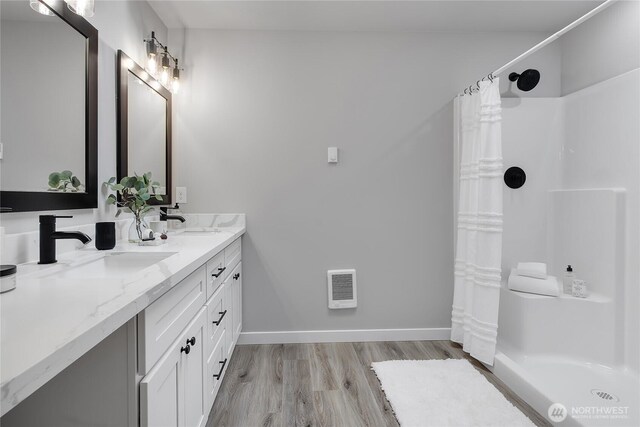 bathroom featuring a sink, visible vents, a shower with shower curtain, and wood finished floors