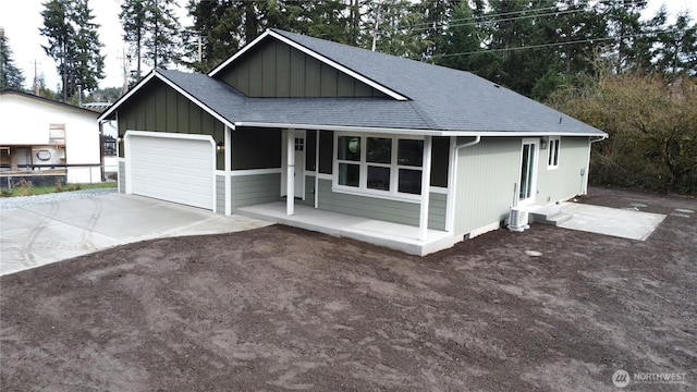 single story home featuring board and batten siding, a porch, concrete driveway, roof with shingles, and a garage