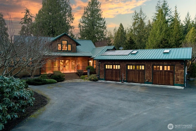 view of front of house with a porch, concrete driveway, and an attached garage