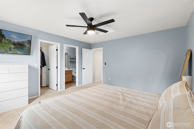 bedroom featuring a spacious closet, connected bathroom, ceiling fan, light carpet, and a closet