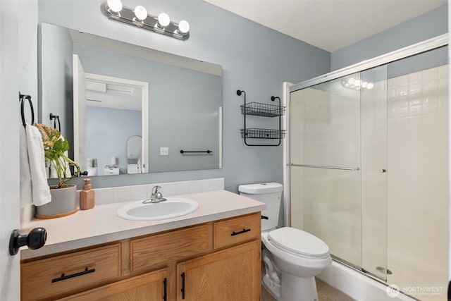 bathroom with vanity, toilet, and a shower stall