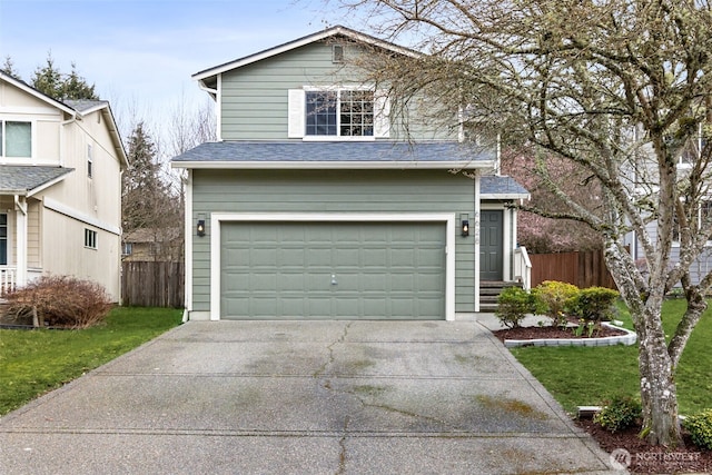 traditional-style house with an attached garage, concrete driveway, a front yard, and fence