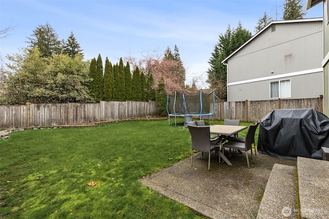 view of yard with a trampoline and a fenced backyard