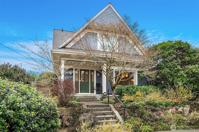 victorian house featuring roof with shingles