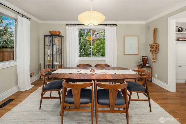 dining area featuring visible vents, baseboards, dark wood-style floors, and crown molding