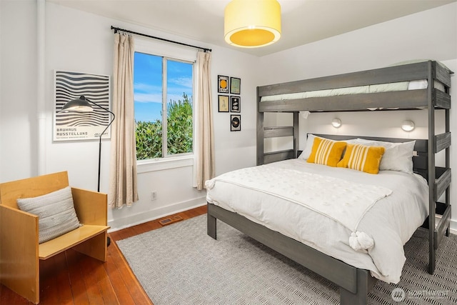 bedroom featuring visible vents, baseboards, and hardwood / wood-style flooring