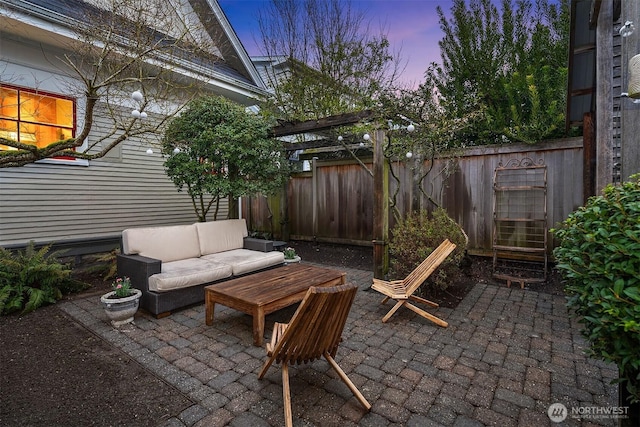 patio terrace at dusk with an outdoor living space, a fenced backyard, and a pergola