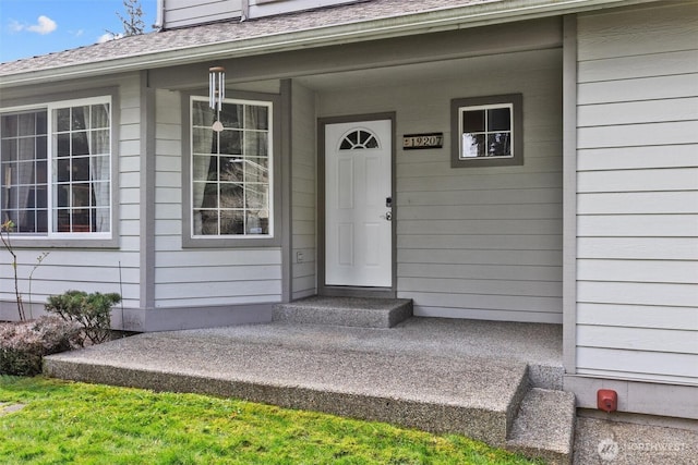 property entrance featuring a shingled roof