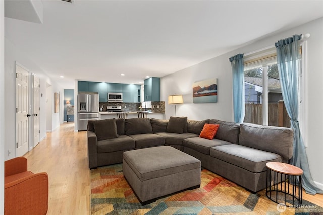 living area featuring recessed lighting, baseboards, and light wood-style floors