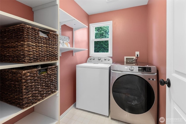 clothes washing area with washer and dryer, laundry area, and baseboards