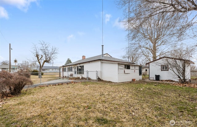 rear view of property with a yard, fence, and a chimney