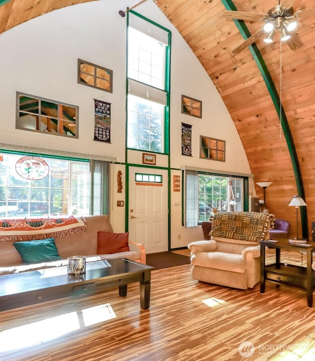 living room with ceiling fan, wood finished floors, wood ceiling, and high vaulted ceiling