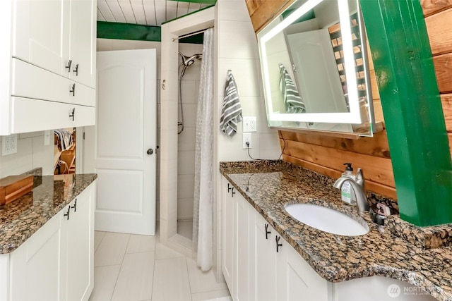 full bathroom with tile patterned floors, a stall shower, and vanity