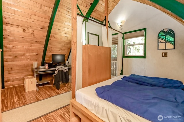 bedroom with wooden ceiling, wooden walls, vaulted ceiling with beams, and wood finished floors