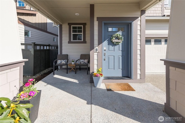 entrance to property featuring covered porch and fence