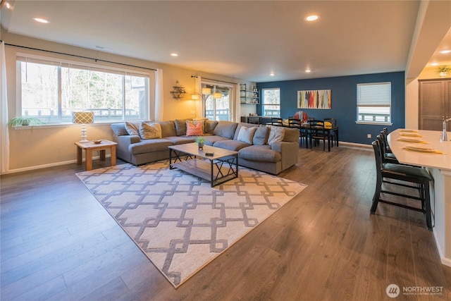 living room with recessed lighting, visible vents, baseboards, and wood finished floors