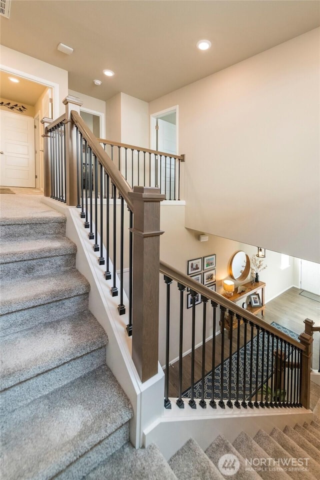 stairway with recessed lighting and wood finished floors