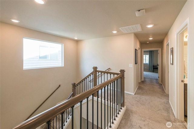 hall with baseboards, visible vents, recessed lighting, light carpet, and an upstairs landing