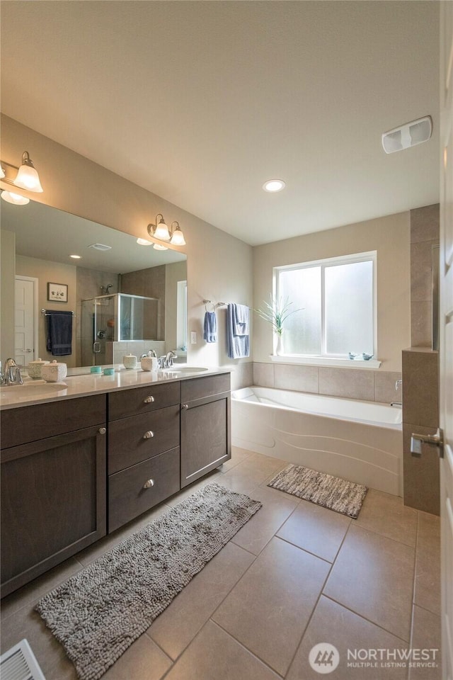 full bathroom featuring tile patterned flooring, visible vents, a stall shower, a bath, and vanity