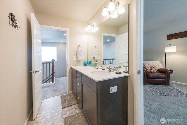 bathroom with a sink, baseboards, and double vanity