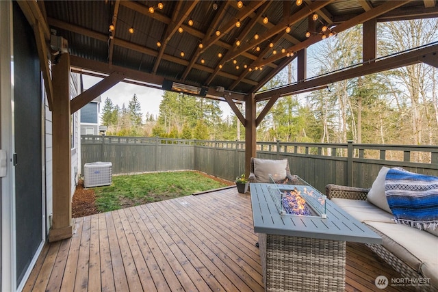 wooden terrace with central AC unit, an outdoor fire pit, and fence