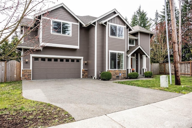 craftsman inspired home with a front lawn, fence, concrete driveway, a garage, and stone siding