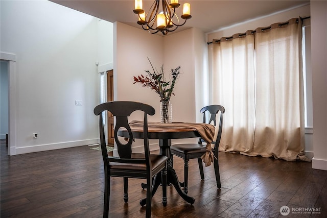 dining room featuring dark wood-type flooring, a healthy amount of sunlight, baseboards, and a chandelier