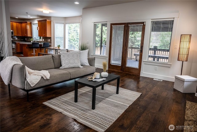 living area with recessed lighting, visible vents, baseboards, and dark wood-style flooring