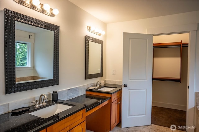 bathroom with double vanity, tile patterned floors, and a sink