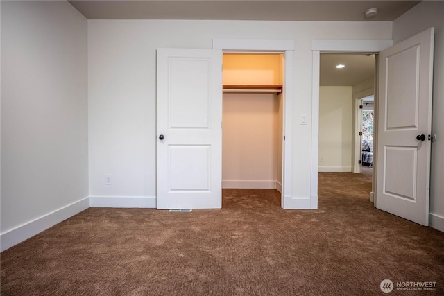 unfurnished bedroom featuring carpet, baseboards, and a closet