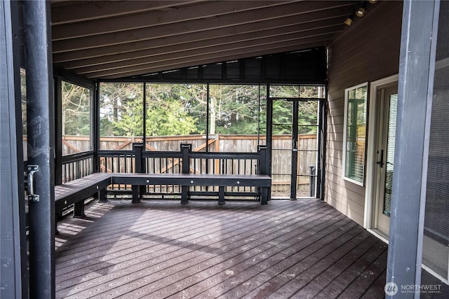 sunroom featuring lofted ceiling and a healthy amount of sunlight