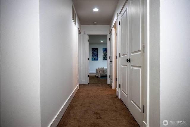 hallway with carpet flooring, recessed lighting, visible vents, and baseboards