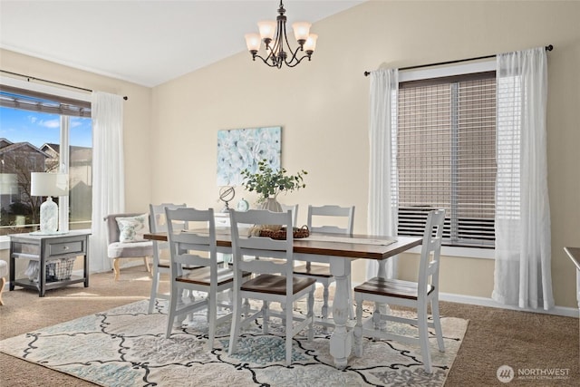 carpeted dining area featuring lofted ceiling, baseboards, and a chandelier