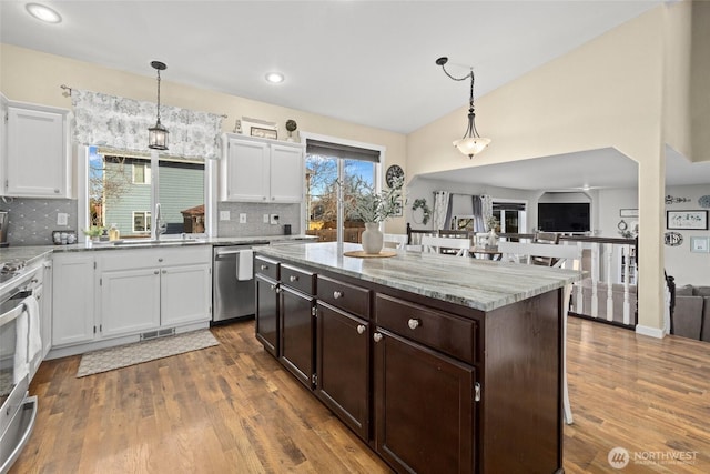 kitchen featuring white cabinetry, dark brown cabinetry, visible vents, and appliances with stainless steel finishes