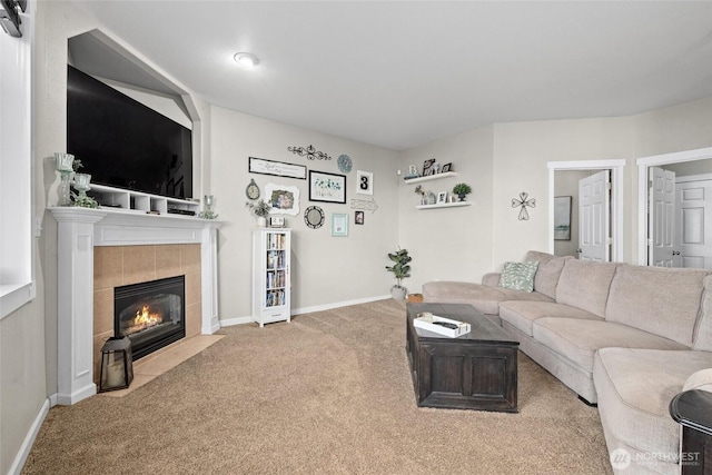 living area featuring a fireplace, baseboards, and carpet