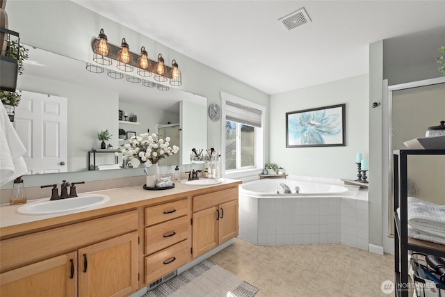 bathroom with a stall shower, a bath, visible vents, and a sink