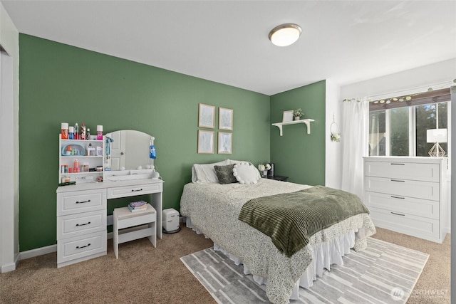 bedroom featuring light colored carpet and baseboards