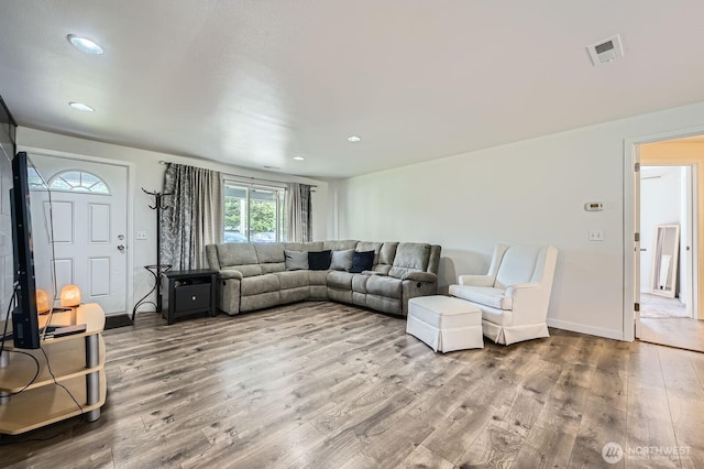 living area with recessed lighting, visible vents, baseboards, and wood finished floors