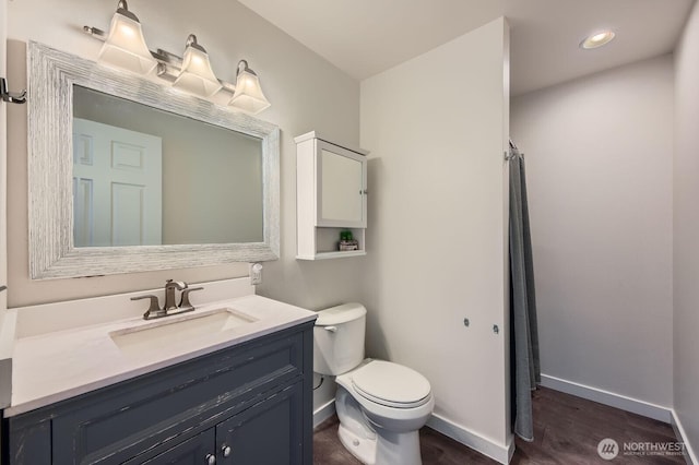 bathroom with vanity, a shower with shower curtain, wood finished floors, baseboards, and toilet