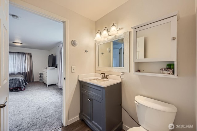 ensuite bathroom with baseboards, toilet, ensuite bath, and vanity