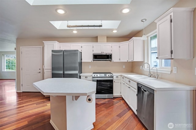 kitchen featuring recessed lighting, a skylight, stainless steel appliances, and a sink