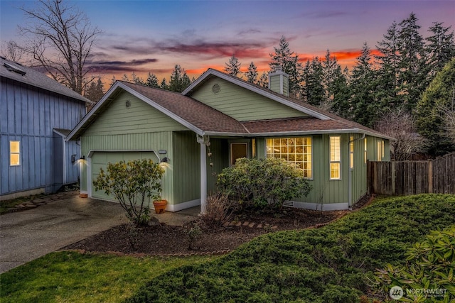 view of front facade with driveway, fence, an attached garage, a shingled roof, and a chimney