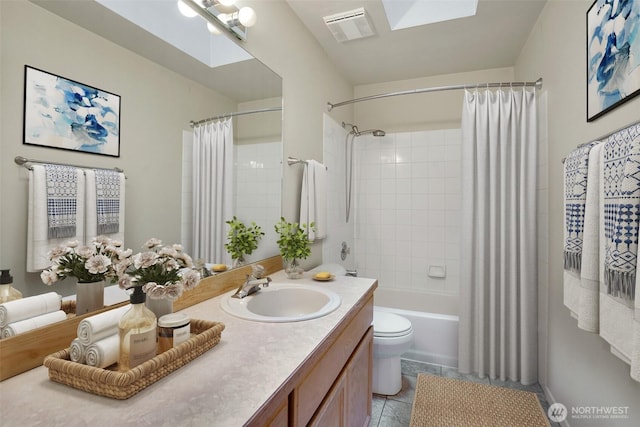 full bathroom with tile patterned flooring, visible vents, toilet, a skylight, and vanity